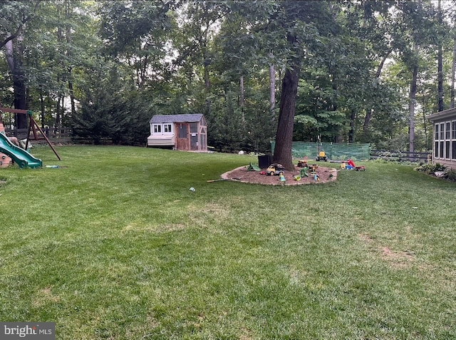 view of yard featuring a shed, a playground, and an outdoor structure