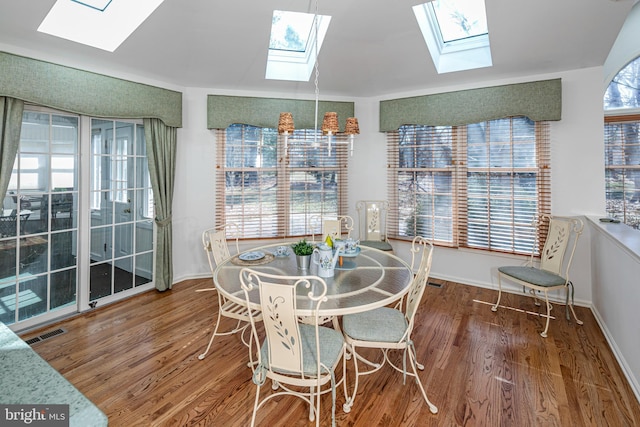 dining room with wood finished floors, visible vents, and baseboards