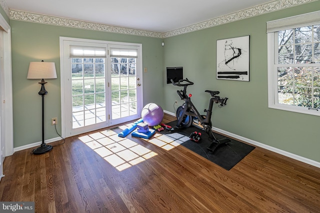 workout area featuring baseboards and wood finished floors