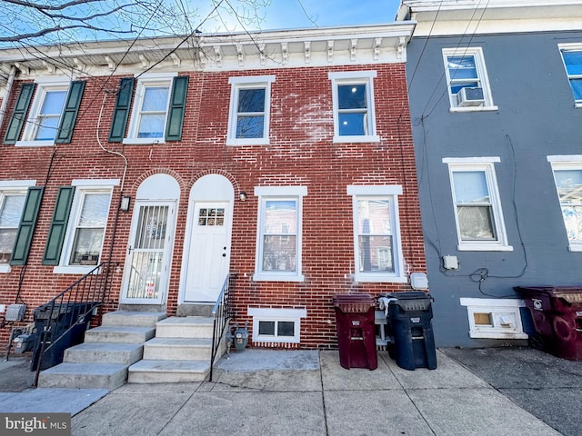 townhome / multi-family property featuring entry steps and brick siding