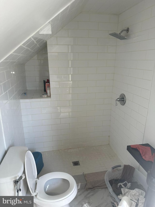 full bath featuring toilet, marble finish floor, a stall shower, and vaulted ceiling