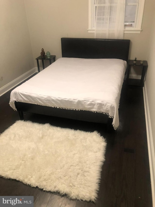 bedroom featuring wood finished floors and baseboards