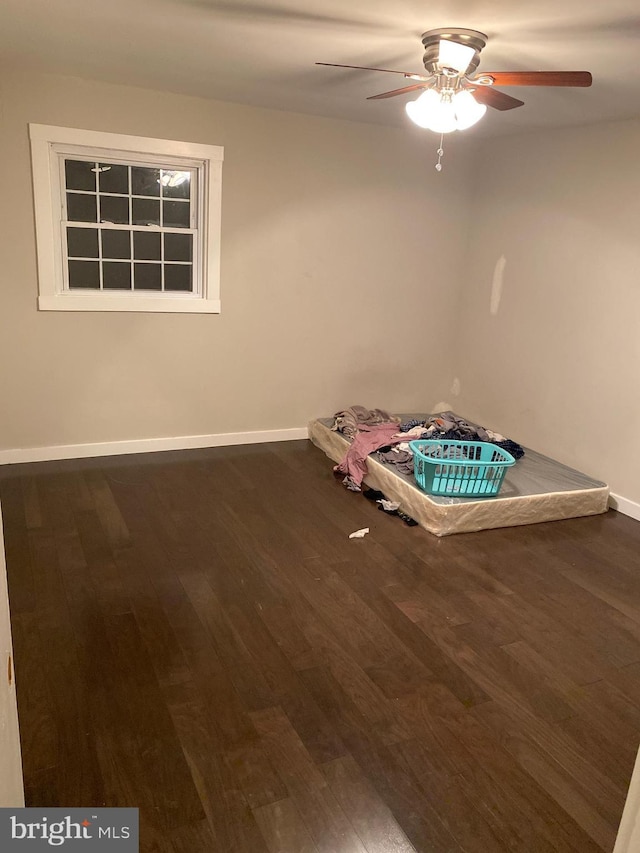 unfurnished bedroom featuring ceiling fan, baseboards, and wood finished floors