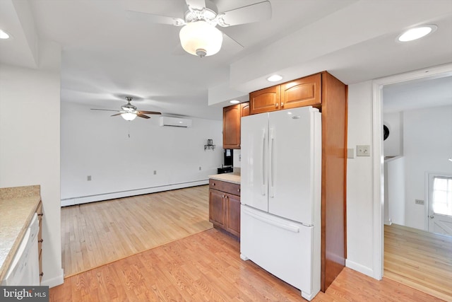 kitchen featuring a wall mounted AC, freestanding refrigerator, ceiling fan, a baseboard heating unit, and light wood-type flooring