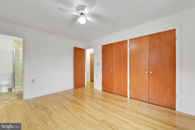 unfurnished bedroom featuring multiple closets, a ceiling fan, connected bathroom, light wood finished floors, and baseboards