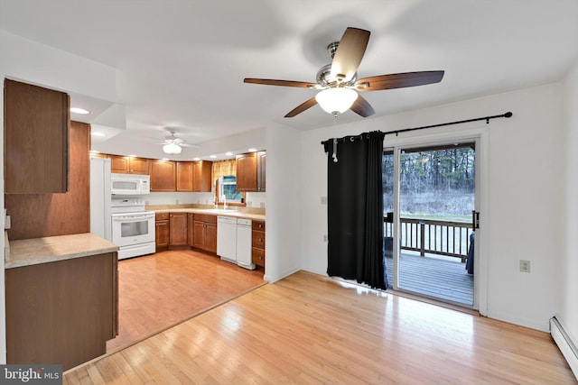 kitchen featuring light wood-type flooring, white appliances, a ceiling fan, and light countertops