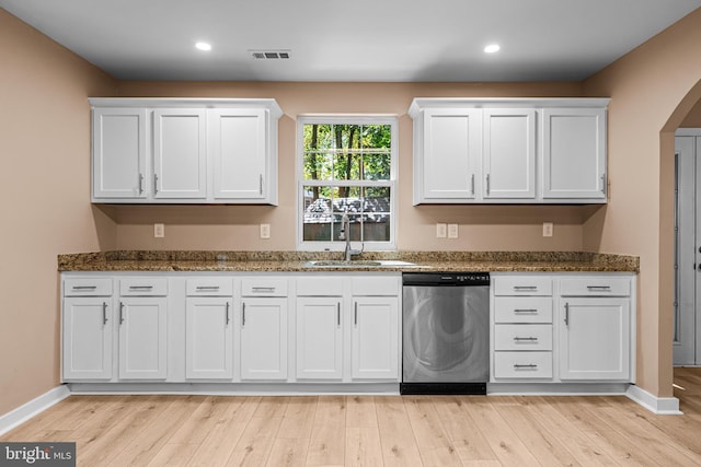 kitchen featuring visible vents, dishwasher, light wood-style floors, white cabinets, and a sink