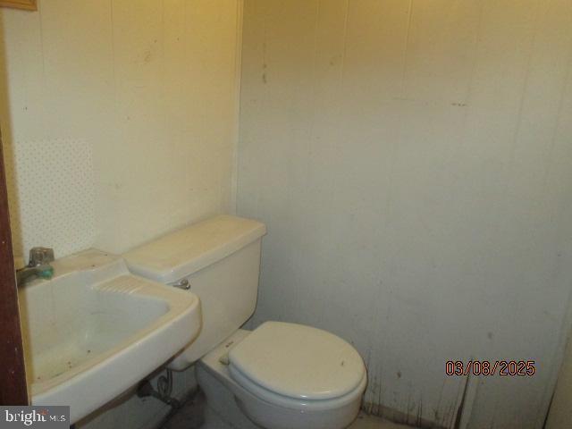 half bathroom featuring toilet and a sink