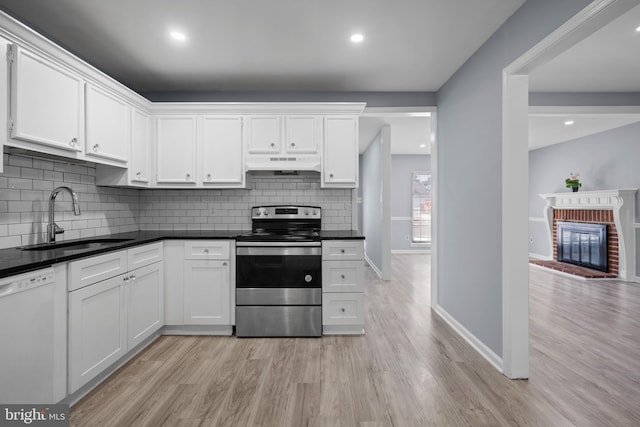 kitchen with light wood-style flooring, stainless steel electric range, a sink, under cabinet range hood, and dishwasher