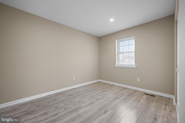 spare room with visible vents, baseboards, and light wood-style floors