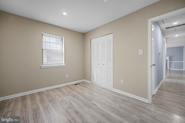 unfurnished bedroom with visible vents, baseboards, light wood-style floors, and a closet