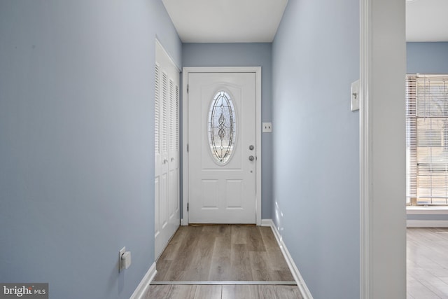 doorway with baseboards and wood finished floors