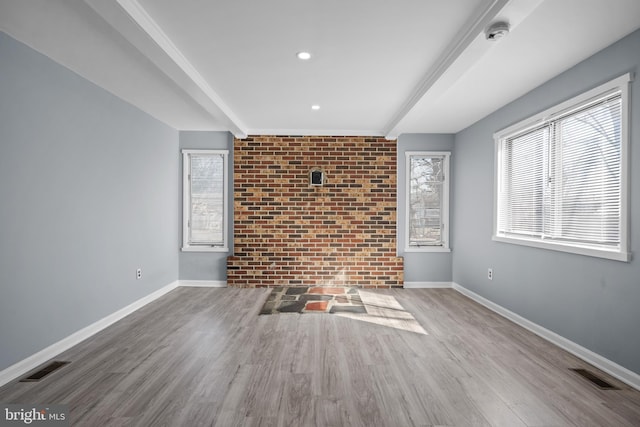 spare room with visible vents, baseboards, and wood finished floors