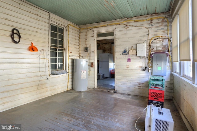 interior space with electric panel, electric water heater, and wooden walls