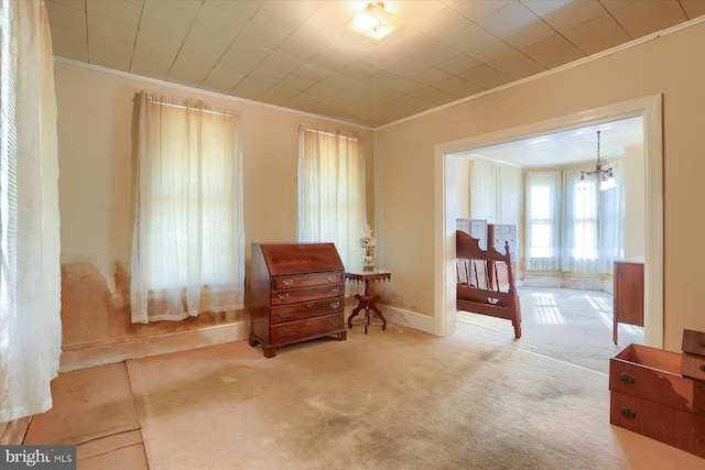 sitting room featuring carpet, baseboards, a chandelier, and ornamental molding