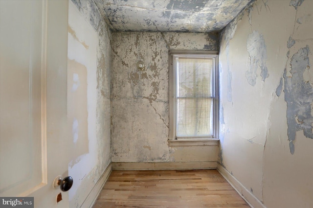 unfurnished room with baseboards and light wood-type flooring