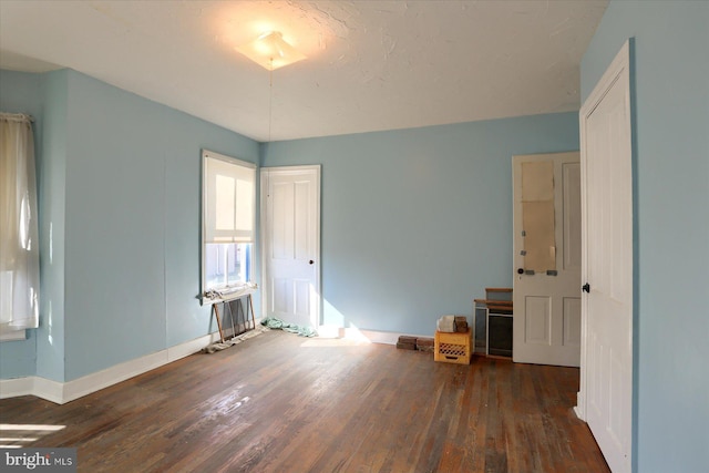 unfurnished bedroom featuring baseboards and wood finished floors