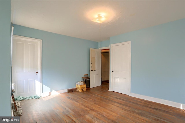 unfurnished bedroom with baseboards and wood finished floors