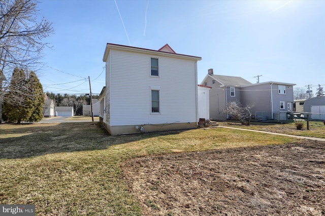 rear view of property featuring a lawn and entry steps