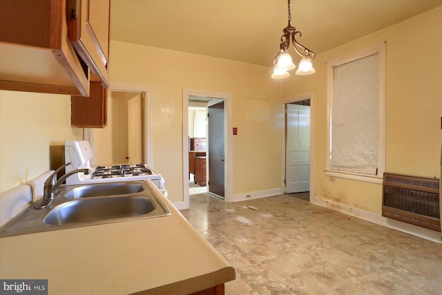 kitchen featuring heating unit, baseboards, white range with gas stovetop, a sink, and pendant lighting