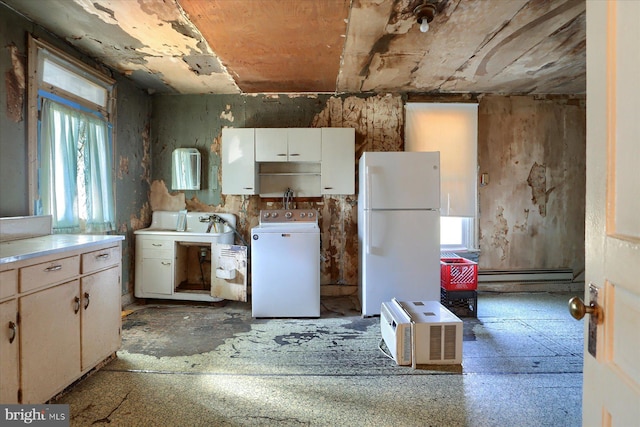 kitchen featuring a baseboard heating unit, freestanding refrigerator, white cabinets, light countertops, and washer / dryer