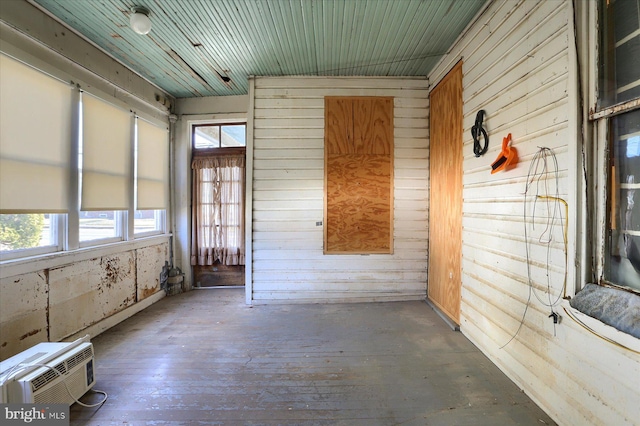 unfurnished sunroom featuring a wall mounted air conditioner