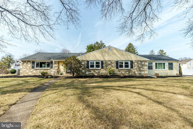 ranch-style house featuring a front yard and stone siding