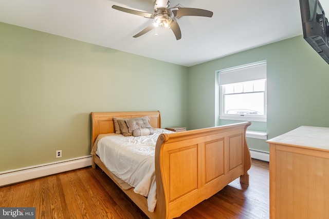 bedroom with a baseboard heating unit, a ceiling fan, and wood finished floors