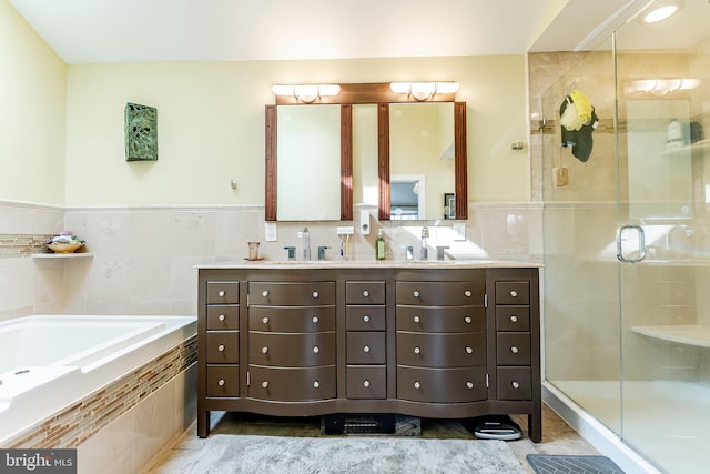 full bath with double vanity, a bath, a stall shower, and a sink