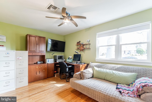 office area with ceiling fan, light wood-style floors, visible vents, and a healthy amount of sunlight