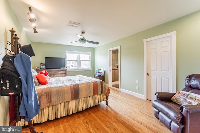 bedroom featuring visible vents, connected bathroom, baseboards, ceiling fan, and light wood-style flooring