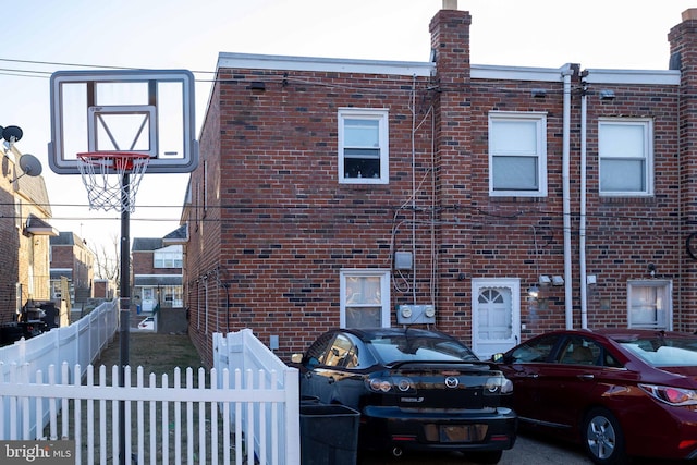 view of front of home featuring brick siding and fence