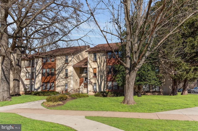 view of front of home featuring stucco siding and a front yard