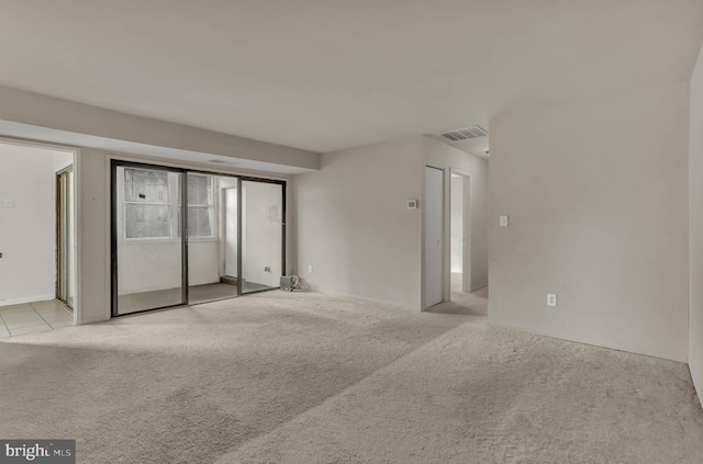 carpeted empty room featuring visible vents