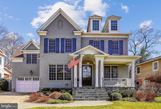 view of front of home featuring an attached garage, brick siding, covered porch, and driveway