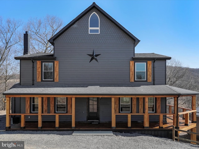 exterior space featuring covered porch and a chimney