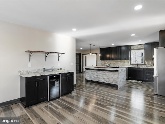 kitchen featuring open shelves, a sink, stainless steel appliances, wine cooler, and backsplash