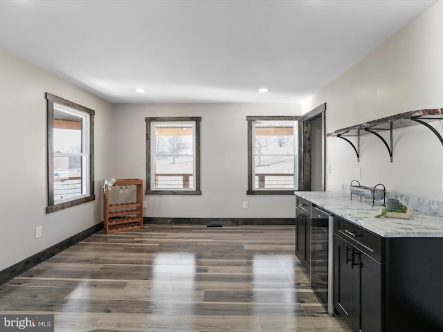 bar featuring dark wood-type flooring, wine cooler, recessed lighting, and baseboards