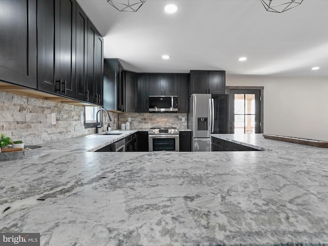 kitchen featuring a sink, decorative backsplash, a healthy amount of sunlight, and stainless steel appliances