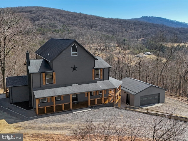 exterior space with a garage, a view of trees, and a mountain view