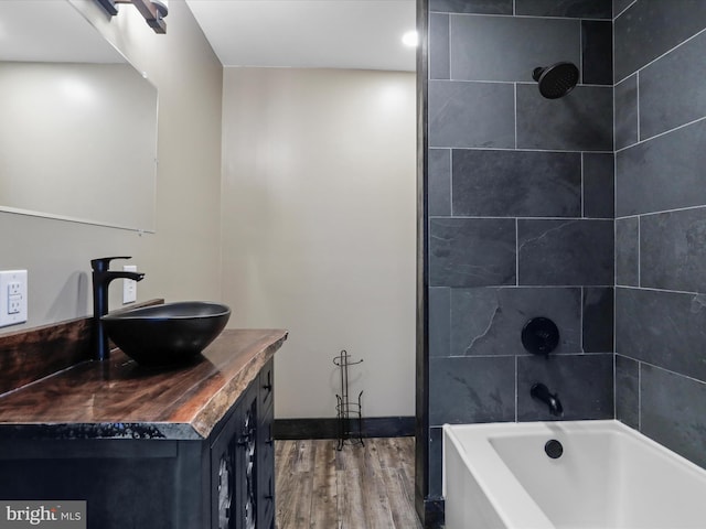 full bathroom featuring baseboards, shower / tub combination, wood finished floors, and vanity