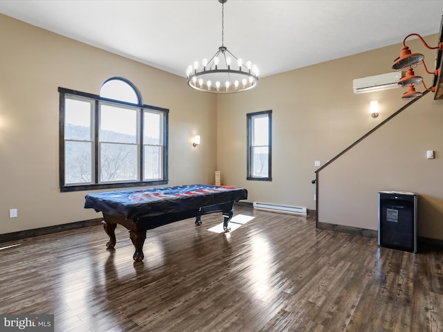 game room featuring a chandelier, an AC wall unit, baseboards, and wood finished floors