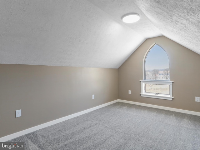 bonus room with carpet flooring, a textured ceiling, lofted ceiling, and baseboards