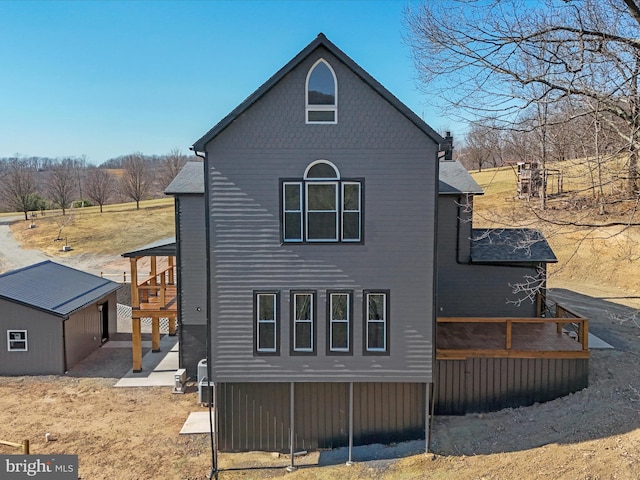 rear view of property with an outbuilding and a deck