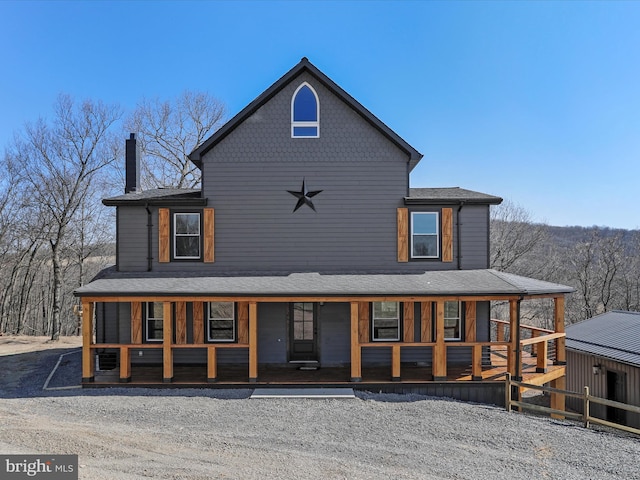 back of property with a porch and a chimney