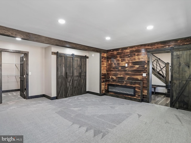 unfurnished living room with stairway, recessed lighting, carpet, and a barn door