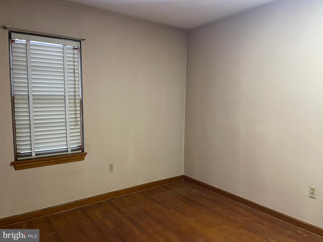 spare room featuring wood finished floors and baseboards