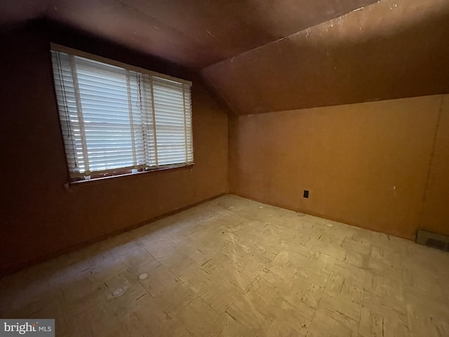 bonus room featuring lofted ceiling, visible vents, and tile patterned floors