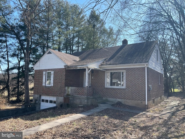 view of front of property featuring a garage, brick siding, roof with shingles, and a chimney