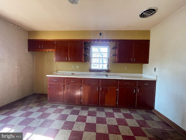 kitchen with visible vents, a sink, light floors, light countertops, and open shelves